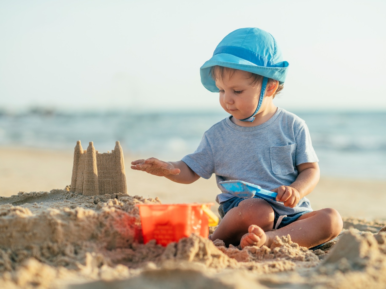 Child building a sandcastle on a beach